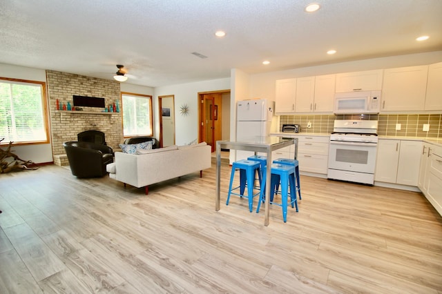 11715 Sorenson Lake Rd, Merrifield, MN 56465 - kitchen featuring white appliances, a ceiling fan, open floor plan, backsplash, and white cabinets