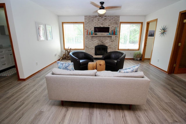 11715 Sorenson Lake Rd, Merrifield, MN 56465 - living area with healthy amount of natural light, a ceiling fan, a brick fireplace, and light wood-style floors
