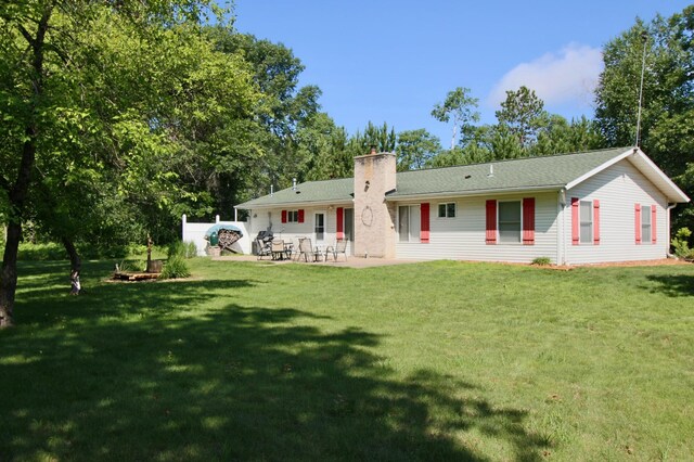 11715 Sorenson Lake Rd, Merrifield, MN 56465 - back of house with a patio, a chimney, a lawn, and view of wooded area