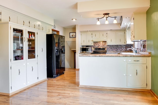 7771 Odean Ave NE, Otsego, MN 55330 - kitchen featuring appliances with stainless steel finishes, a peninsula, light wood-style flooring, and decorative backsplash
