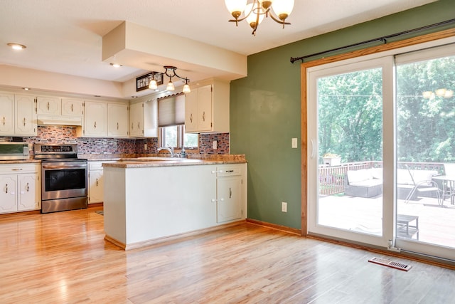 7771 Odean Ave NE, Otsego, MN 55330 - kitchen featuring appliances with stainless steel finishes, light wood finished floors, a chandelier, and tasteful backsplash