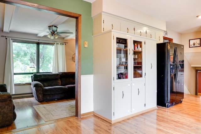 7771 Odean Ave NE, Otsego, MN 55330 - kitchen featuring black fridge, light wood-style floors, ceiling fan, baseboard heating, and white cabinets