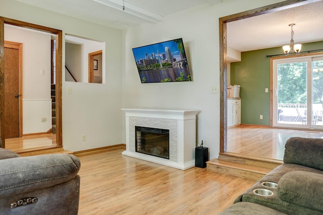 7771 Odean Ave NE, Otsego, MN 55330 - living room with wood finished floors, a fireplace, and a chandelier