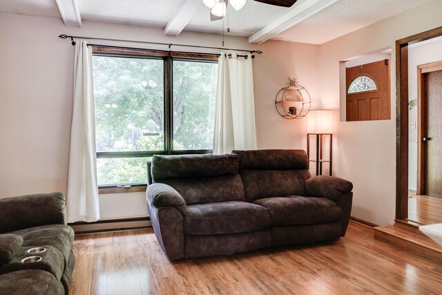 7771 Odean Ave NE, Otsego, MN 55330 - living room with a baseboard heating unit, ceiling fan, beam ceiling, and light wood-style floors