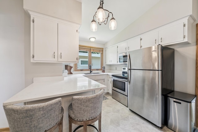 1073 Allen Ave W, Saint Paul, MN 55118 - kitchen featuring stainless steel appliances, a peninsula, light countertops, white cabinets, and vaulted ceiling