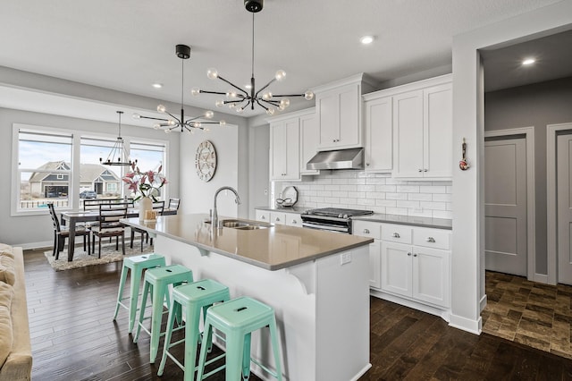 2301 Kester Ave NE, Saint Michael, MN 55376 - kitchen featuring under cabinet range hood, a chandelier, stainless steel gas range, an island with sink, and recessed lighting