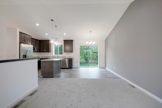 37554 Greenwich Ct, North Branch, MN 55056 - kitchen featuring stainless steel appliances, dark brown cabinets, light colored carpet, a chandelier, and a kitchen island
