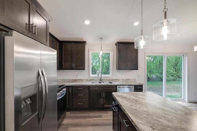 37554 Greenwich Ct, North Branch, MN 55056 - kitchen with appliances with stainless steel finishes, dark brown cabinetry, healthy amount of natural light, light stone countertops, and recessed lighting