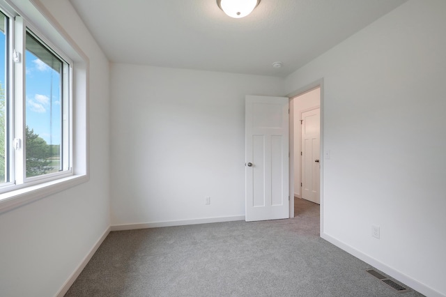 37554 Greenwich Ct, North Branch, MN 55056 - carpeted empty room featuring plenty of natural light and a smoke detector