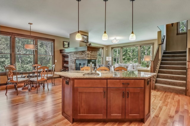 860 Prairie Meadows Dr, Hudson, WI 54016 - kitchen with light wood finished floors, open floor plan, light stone countertops, and a stone fireplace