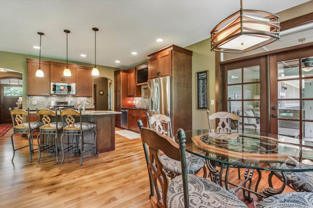 860 Prairie Meadows Dr, Hudson, WI 54016 - dining room featuring arched walkways, light wood-type flooring, and recessed lighting