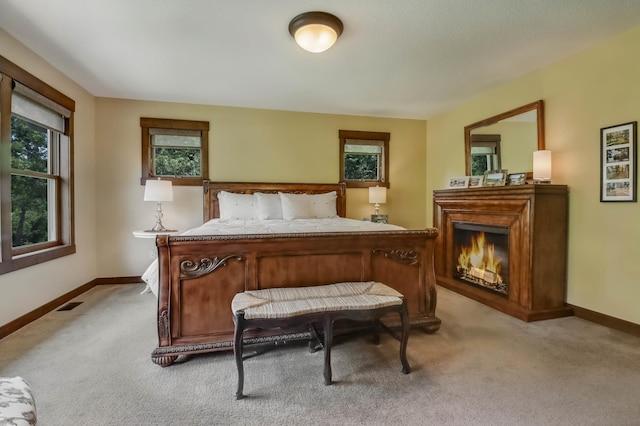 860 Prairie Meadows Dr, Hudson, WI 54016 - bedroom with light carpet and a lit fireplace