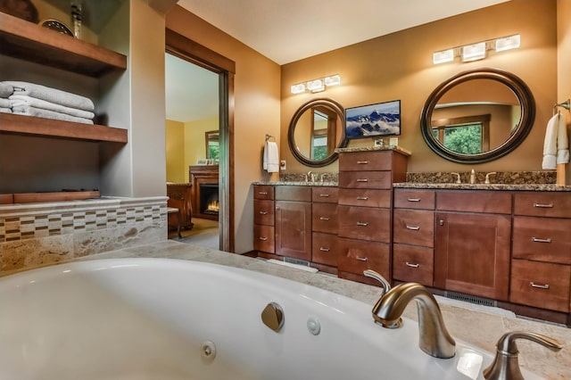 860 Prairie Meadows Dr, Hudson, WI 54016 - full bathroom featuring double vanity, a whirlpool tub, and a lit fireplace