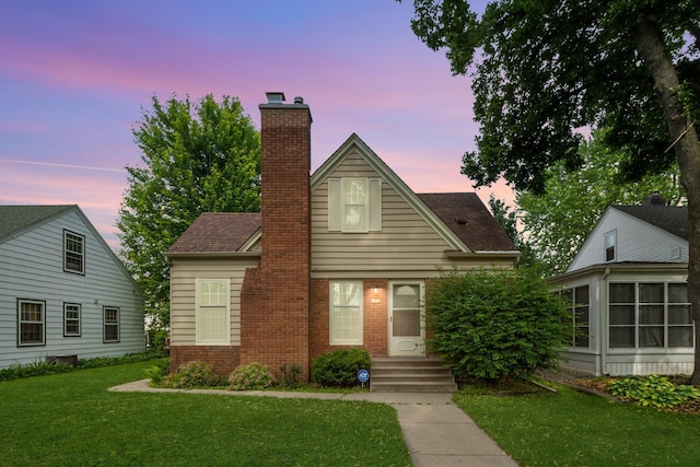 5924 10th Ave S, Minneapolis, MN 55417 - view of front of home featuring brick siding, a chimney, a front lawn, and a sunroom