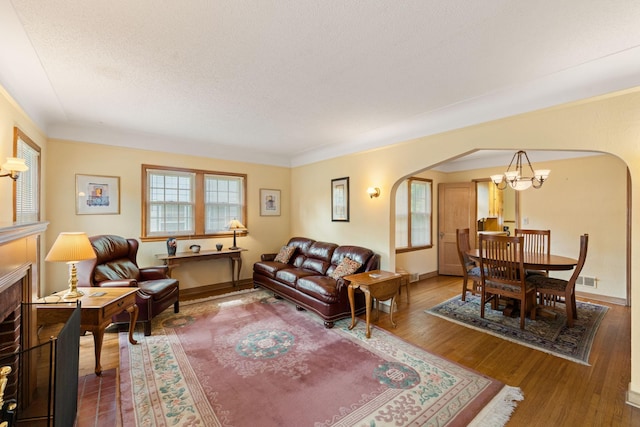 5924 10th Ave S, Minneapolis, MN 55417 - living area with arched walkways, a chandelier, wood finished floors, and a textured ceiling