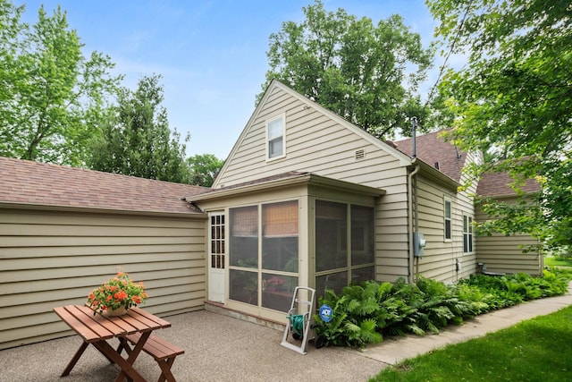 5924 10th Ave S, Minneapolis, MN 55417 - rear view of house featuring a sunroom, a patio, and a shingled roof