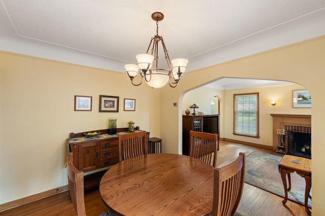 5924 10th Ave S, Minneapolis, MN 55417 - dining space featuring arched walkways, wood finished floors, a chandelier, and a fireplace