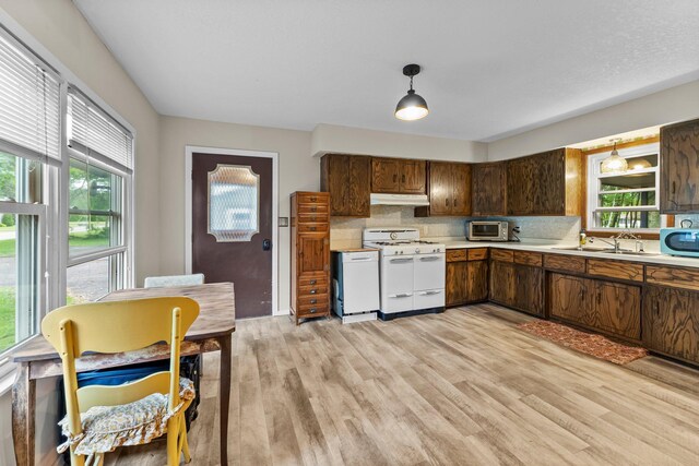 27900 Old Towne Rd, Chisago City, MN 55013 - kitchen with white gas stove, under cabinet range hood, healthy amount of natural light, and light countertops