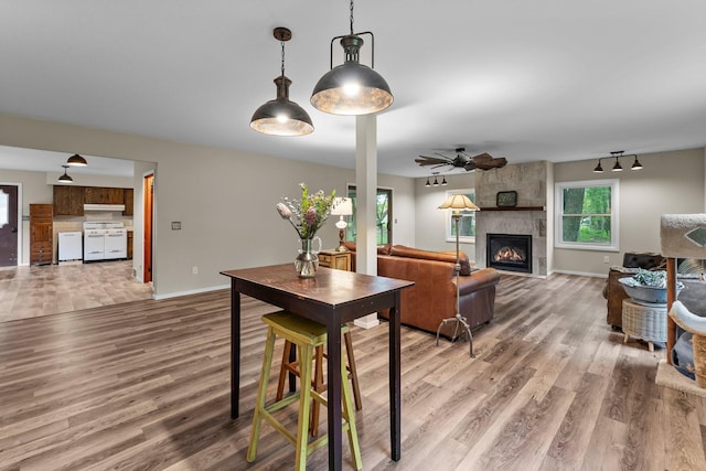 27900 Old Towne Rd, Chisago City, MN 55013 - dining room featuring wood finished floors, a large fireplace, and a ceiling fan