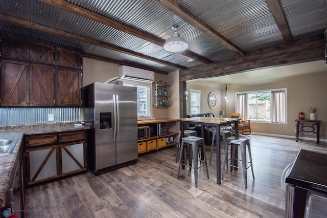 1514 1st Ave S, Fargo, ND 58103 - kitchen with stainless steel refrigerator with ice dispenser, an AC wall unit, range, wood finished floors, and dark brown cabinetry