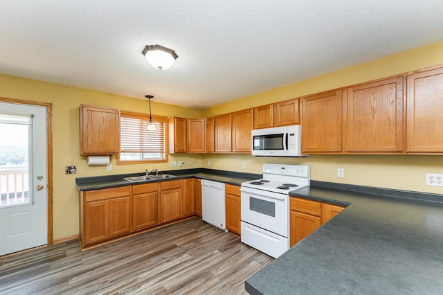 4540 Prairie View Pl NW, Rochester, MN 55901 - kitchen featuring white appliances, dark countertops, light wood finished floors, and hanging light fixtures