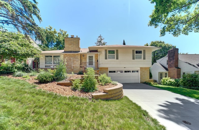 1636 9th Ave NE, Rochester, MN 55906 - split level home featuring a chimney, a garage, concrete driveway, and a front lawn