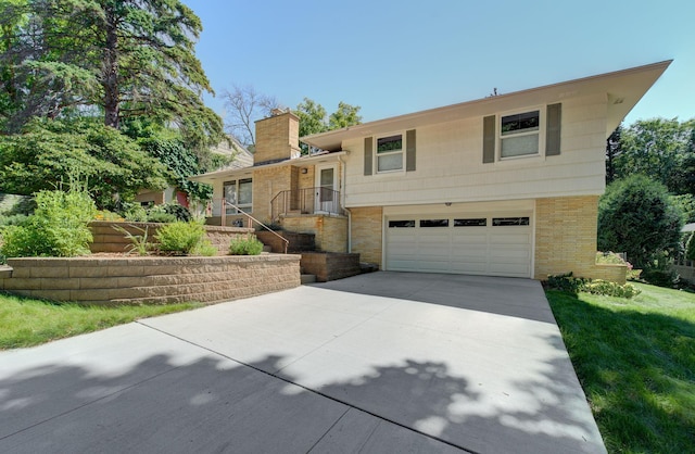 1636 9th Ave NE, Rochester, MN 55906 - tri-level home with concrete driveway, an attached garage, a chimney, and brick siding