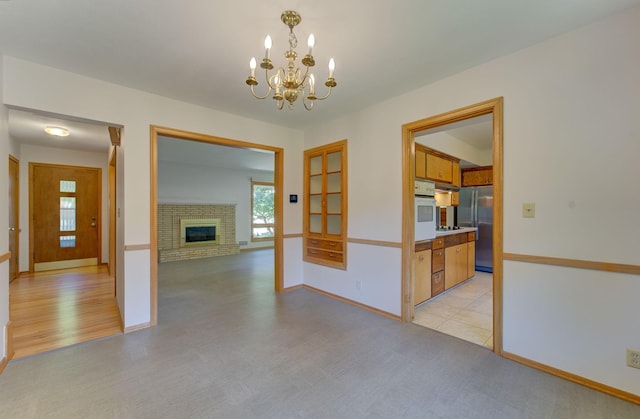 1636 9th Ave NE, Rochester, MN 55906 - spare room featuring a chandelier and a brick fireplace