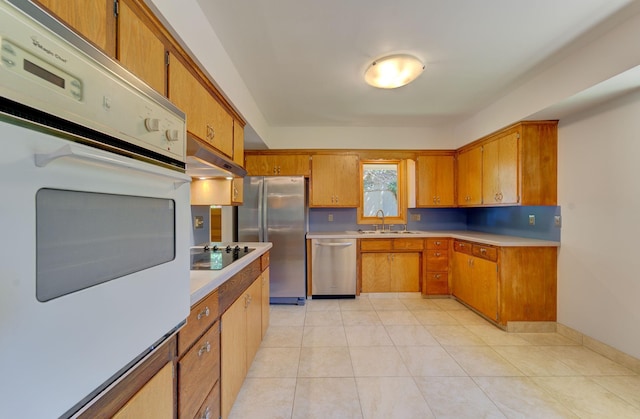 1636 9th Ave NE, Rochester, MN 55906 - kitchen featuring stainless steel appliances, brown cabinets, under cabinet range hood, and light countertops