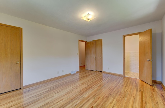 1636 9th Ave NE, Rochester, MN 55906 - unfurnished bedroom with light wood-style floors and connected bathroom