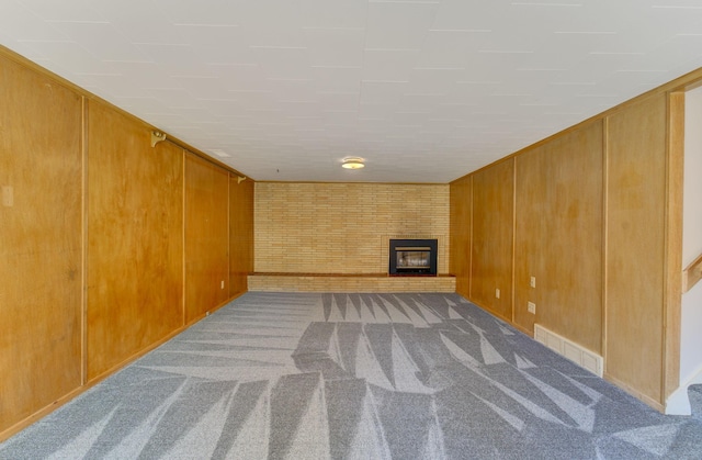 1636 9th Ave NE, Rochester, MN 55906 - unfurnished living room featuring carpet flooring, a brick fireplace, and wood walls