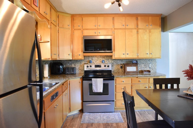 16014 240th St, Cold Spring, MN 56320 - kitchen with stainless steel appliances, wood finished floors, backsplash, and light stone counters
