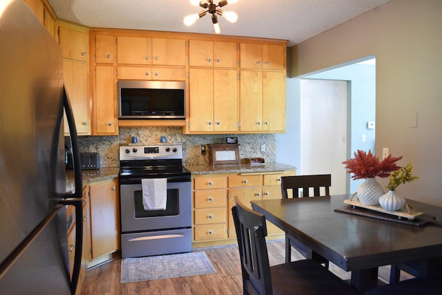 16014 240th St, Cold Spring, MN 56320 - kitchen featuring stainless steel appliances, wood finished floors, and backsplash
