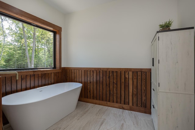 2018 County 5 NW, Hackensack, MN 56452 - bathroom featuring a freestanding bath, wooden walls, and a wainscoted wall