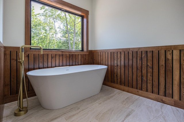 2018 County 5 NW, Hackensack, MN 56452 - bathroom featuring a freestanding bath, a wainscoted wall, and wooden walls