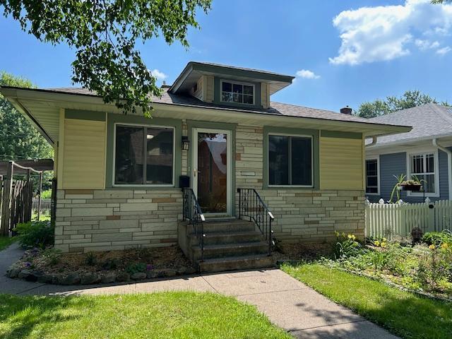 1464 Sheldon St, Saint Paul, MN 55108 - bungalow-style home with stone siding, entry steps, and a shingled roof