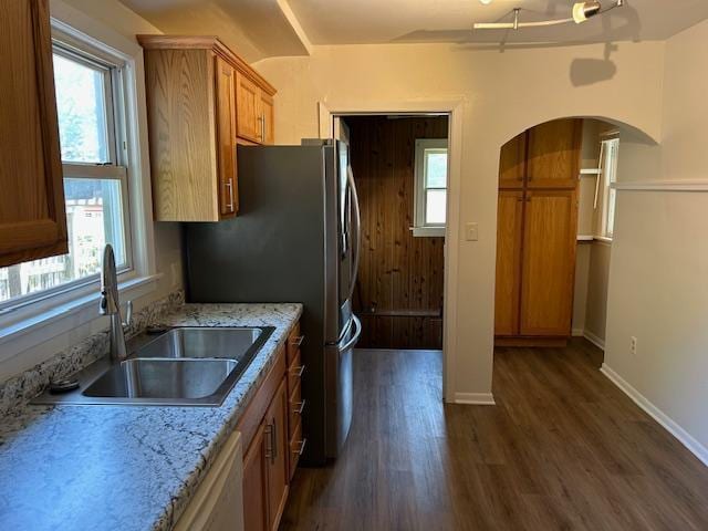 1464 Sheldon St, Saint Paul, MN 55108 - kitchen featuring dark wood-style flooring, brown cabinetry, healthy amount of natural light, and arched walkways