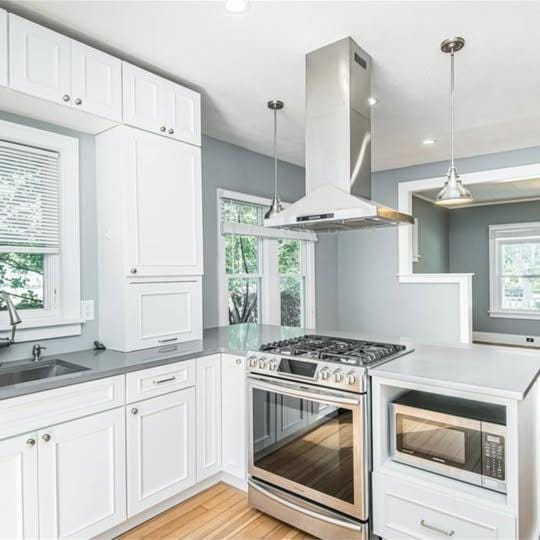 20 12th St NE, Rochester, MN 55906 - kitchen with stainless steel appliances, island range hood, plenty of natural light, white cabinetry, and recessed lighting