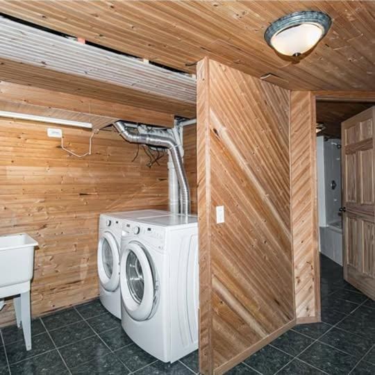 20 12th St NE, Rochester, MN 55906 - washroom featuring wooden walls, independent washer and dryer, dark tile patterned floors, and wooden ceiling
