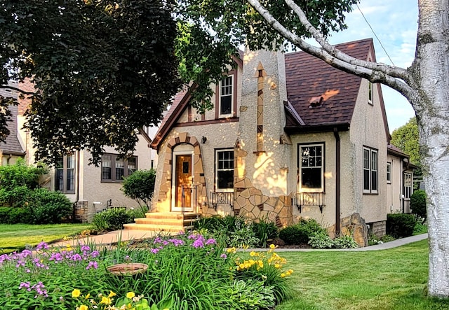 5015 17th Ave S, Minneapolis, MN 55417 - tudor house featuring stucco siding, a shingled roof, and a front lawn