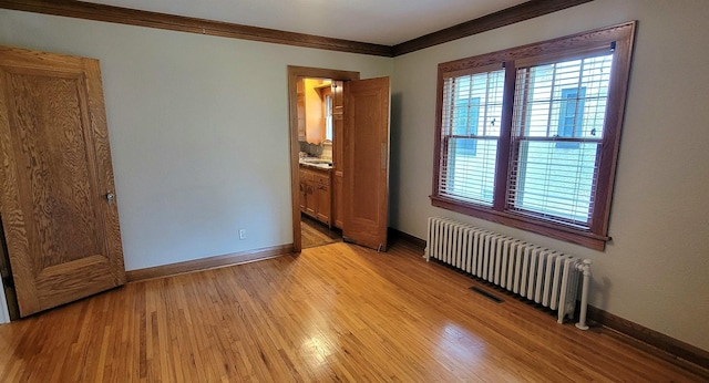 5015 17th Ave S, Minneapolis, MN 55417 - empty room with radiator, ornamental molding, and light wood finished floors