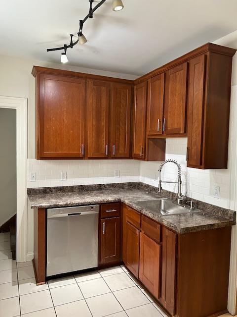 3022 32nd Ave S, Minneapolis, MN 55406 - kitchen featuring stainless steel dishwasher, dark countertops, light tile patterned flooring, and tasteful backsplash
