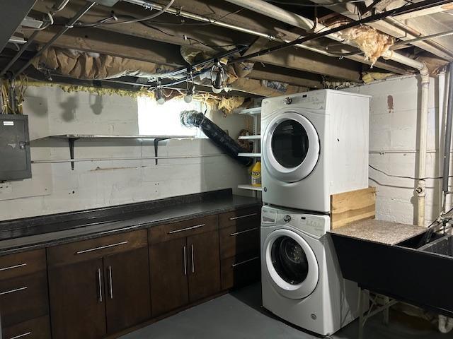 3022 32nd Ave S, Minneapolis, MN 55406 - laundry area featuring stacked washer / drying machine, electric panel, and cabinet space