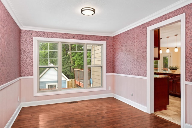 11735 52nd Ave N, Plymouth, MN 55442 - unfurnished room with a wainscoted wall, wood-type flooring, wallpapered walls, and crown molding