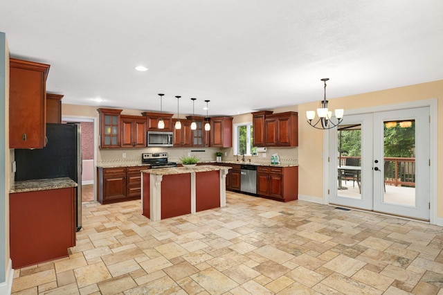 11735 52nd Ave N, Plymouth, MN 55442 - kitchen featuring appliances with stainless steel finishes, a kitchen island, stone tile floors, a chandelier, and decorative light fixtures