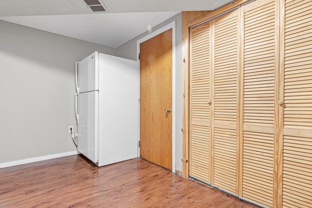 4405 6th St NE, Columbia Heights, MN 55421 - unfurnished bedroom with freestanding refrigerator, a closet, and wood finished floors
