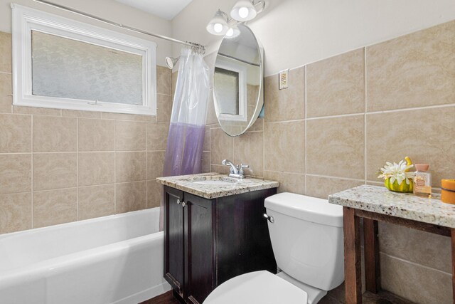 4405 6th St NE, Columbia Heights, MN 55421 - full bath featuring tile walls, vanity, and shower / tub combo with curtain