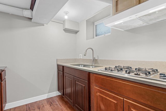 4405 6th St NE, Columbia Heights, MN 55421 - kitchen featuring range hood, wood finished floors, light countertops, and gas stovetop