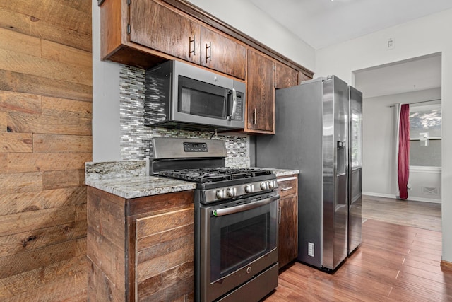 4405 6th St NE, Columbia Heights, MN 55421 - kitchen with appliances with stainless steel finishes, decorative backsplash, light wood-style flooring, and light stone counters