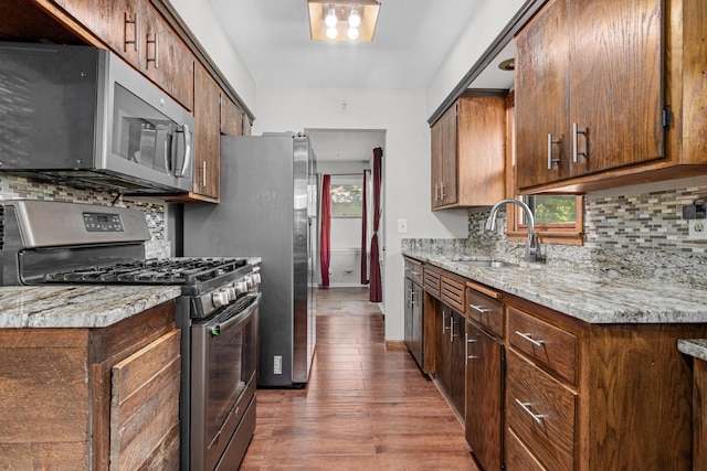 4405 6th St NE, Columbia Heights, MN 55421 - kitchen featuring stainless steel appliances, decorative backsplash, wood finished floors, and healthy amount of natural light